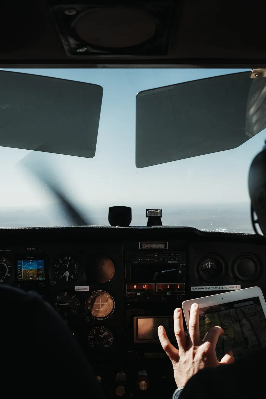 Cockpit view of a Cessna instrument panel with a pilot using an iPad chart during a SimpliFly flying lesson