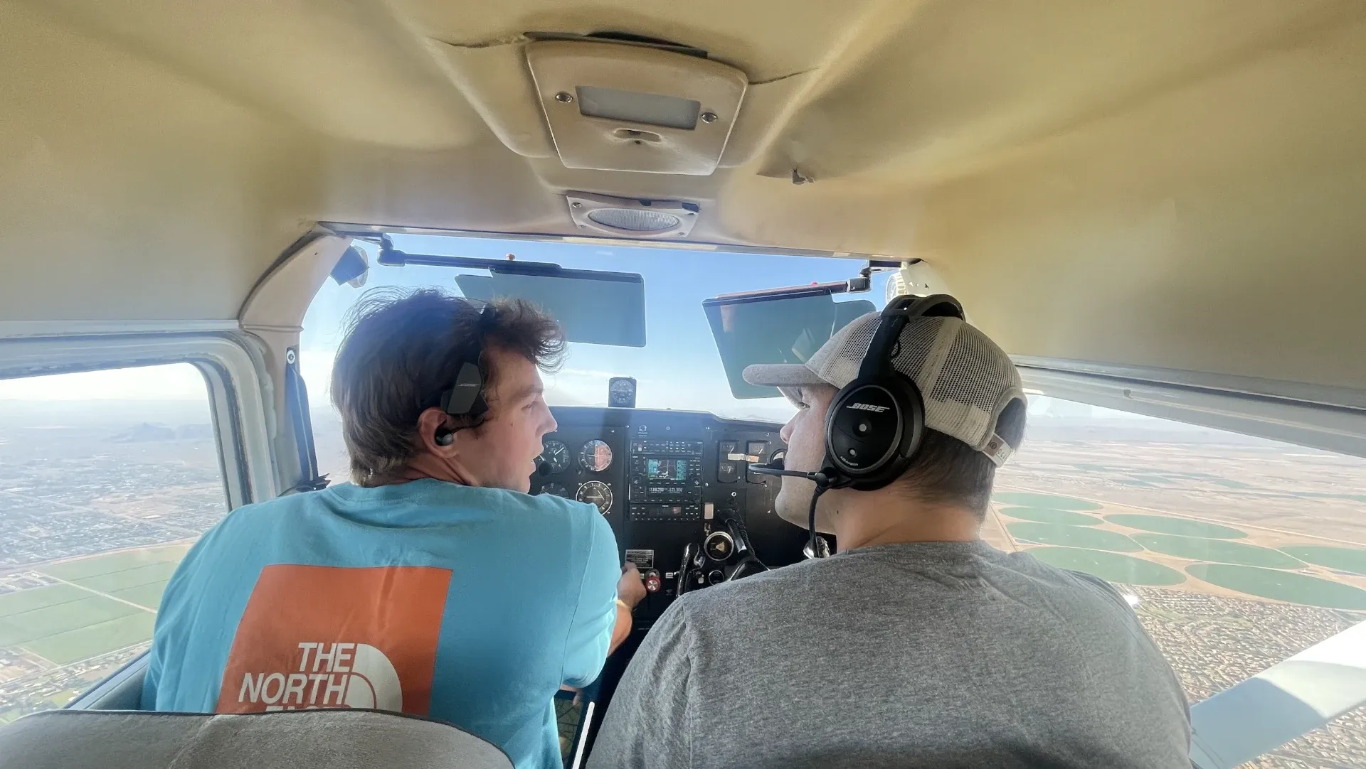 Pilots seen from the back in cockpit of flying airplane