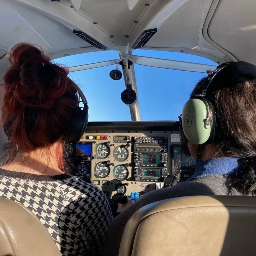 Two pilots in aircraft cockpit during flight seen from the back