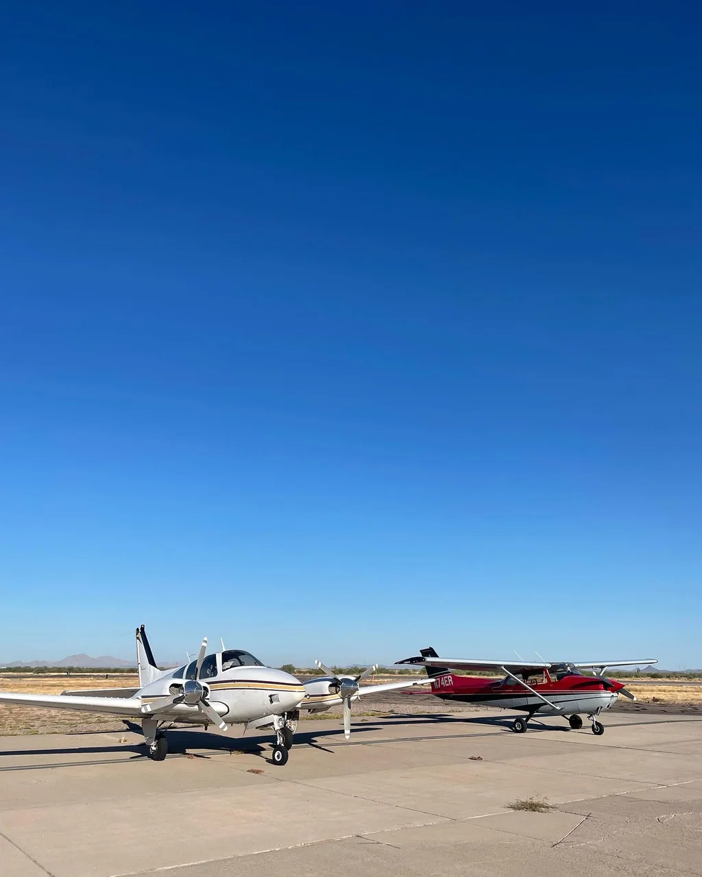 Two flight-training airplanes parked together on an Arizona airport ramp
