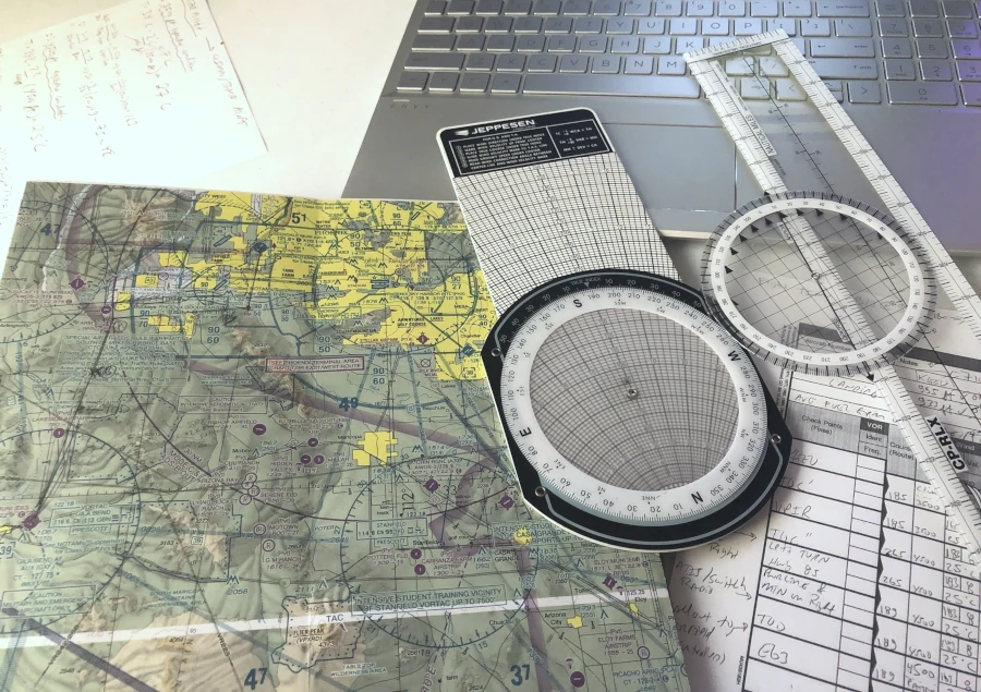E6B plotter, map, and laptop on table